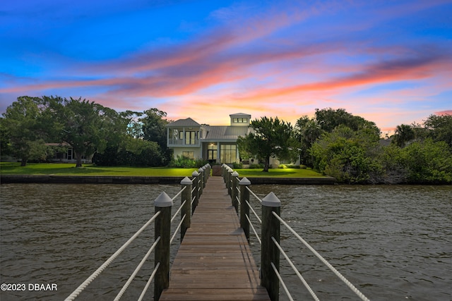 dock area featuring a water view and a lawn