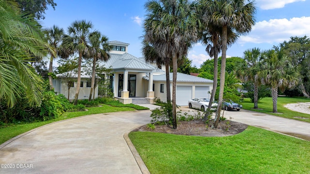 200 John Anderson Dr, Ormond Beach, FL 32176 - view of front of property with concrete driveway, a front yard, metal roof, and a standing seam roof