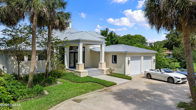 view of front facade featuring a porch, a front lawn, and a garage