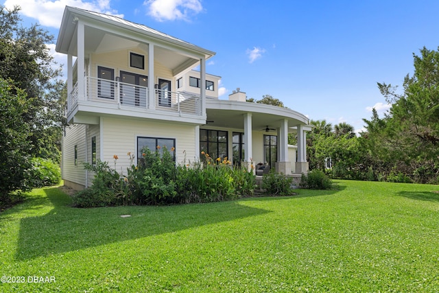 view of front facade with a front lawn, a balcony, and ceiling fan