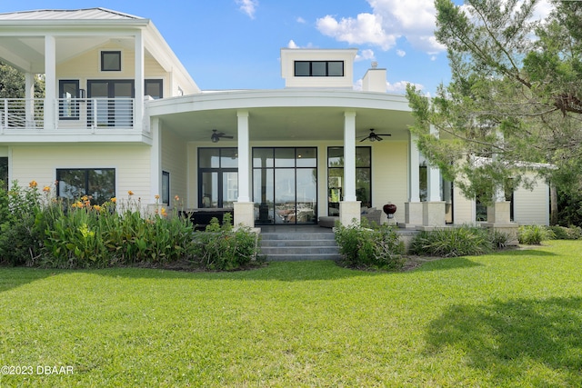 back of house featuring a lawn, ceiling fan, and a balcony