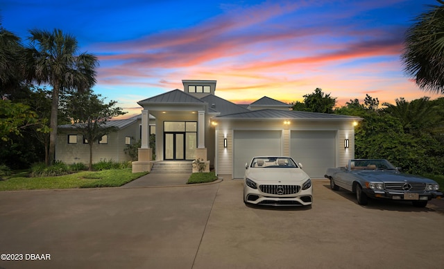 200 John Anderson Dr, Ormond Beach, FL 32176 - view of front of home with driveway, a standing seam roof, a garage, and metal roof