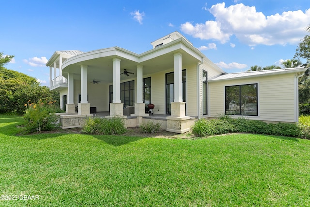 rear view of house featuring a lawn, ceiling fan, and a porch