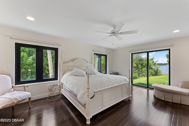 bedroom featuring dark hardwood / wood-style flooring, multiple windows, and ceiling fan