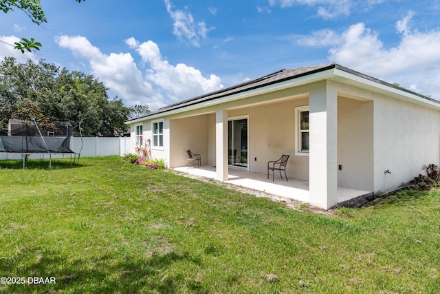 19 Russman Ln, Palm Coast, FL 32164 - rear view of house featuring a trampoline, a patio area, and stucco siding