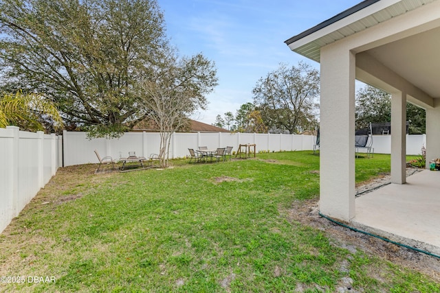 19 Russman Ln, Palm Coast, FL 32164 - fenced backyard featuring a trampoline and a patio area