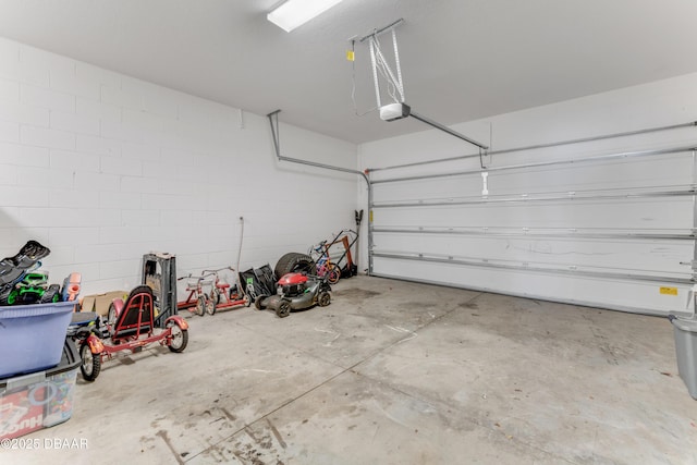 garage with concrete block wall and a garage door opener