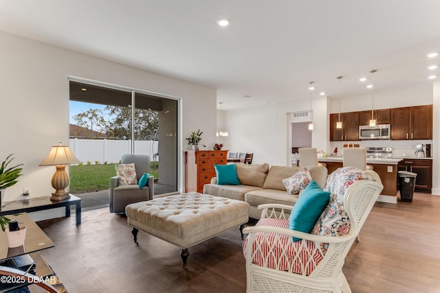 living room with light wood finished floors and recessed lighting