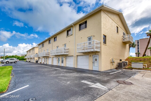 view of building exterior with central AC unit and a garage