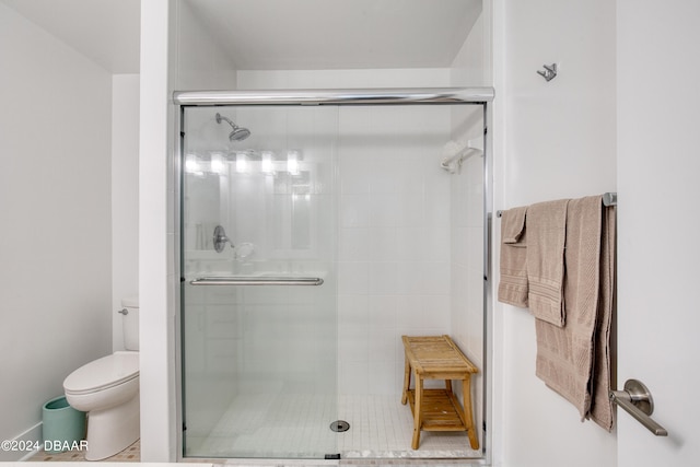 bathroom featuring toilet and an enclosed shower