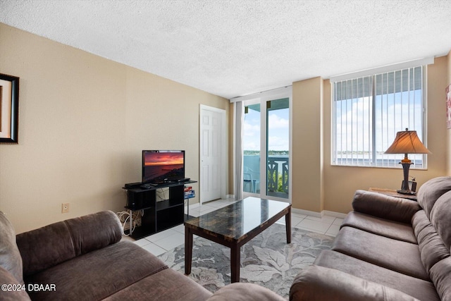 living room with floor to ceiling windows, a textured ceiling, and light tile patterned floors