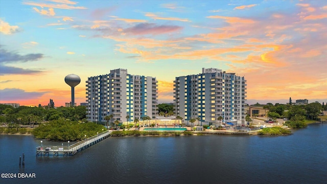 aerial view at dusk featuring a water view