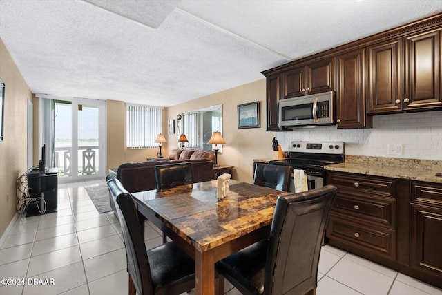 dining area with a textured ceiling and light tile patterned floors