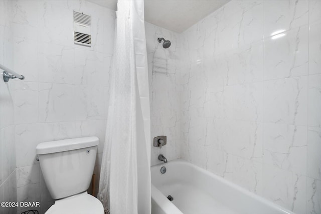 bathroom featuring shower / bath combo with shower curtain and toilet