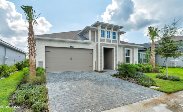 view of front of property with a garage and a front lawn