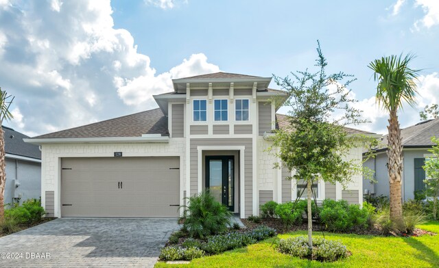 128 Mosaic Blvd, Daytona Beach, FL 32124 - view of front of house featuring decorative driveway, an attached garage, and roof with shingles