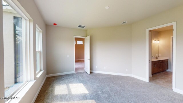 128 Mosaic Blvd, Daytona Beach, FL 32124 - unfurnished bedroom featuring light colored carpet, baseboards, a sink, and ensuite bathroom