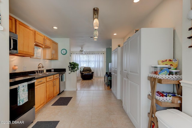 kitchen featuring a sink, dark countertops, recessed lighting, stainless steel appliances, and light tile patterned flooring