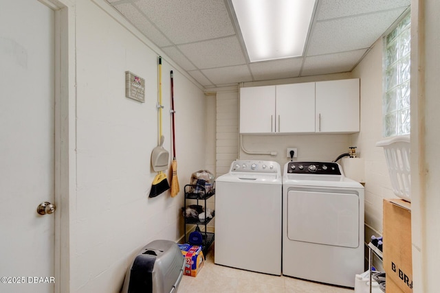 clothes washing area featuring cabinet space and washer and clothes dryer