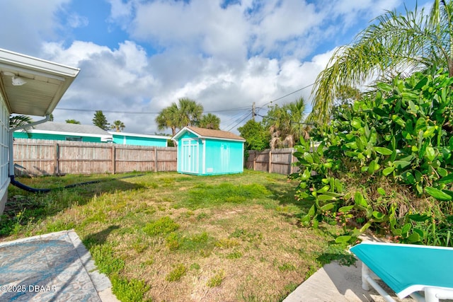 view of yard with a storage shed, a fenced backyard, and an outdoor structure