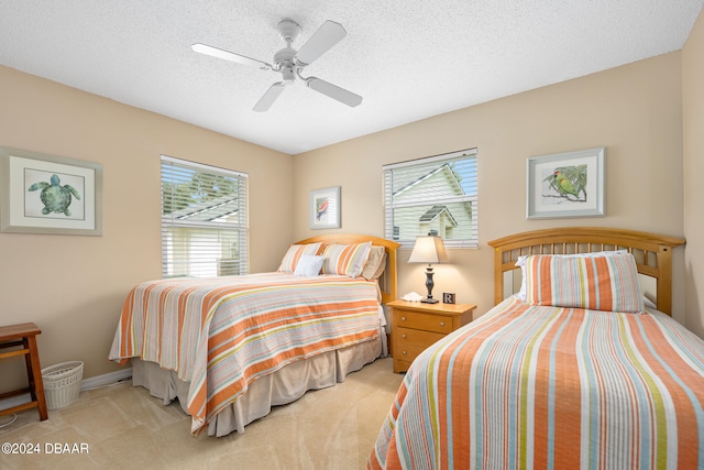 carpeted bedroom with ceiling fan, multiple windows, and a textured ceiling