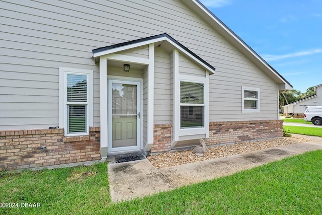 doorway to property featuring a lawn