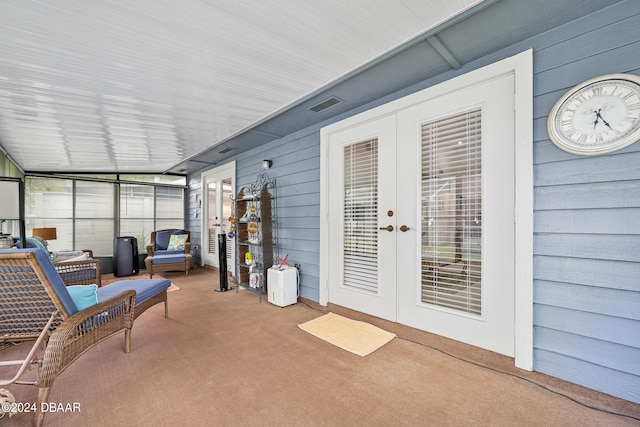 sunroom / solarium featuring lofted ceiling and french doors