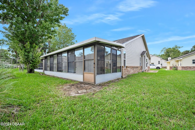 rear view of house with a sunroom and a yard