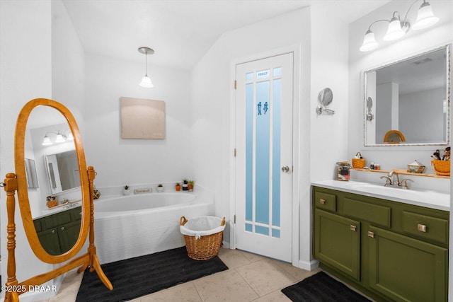 bathroom with tile patterned flooring, vanity, and tiled tub