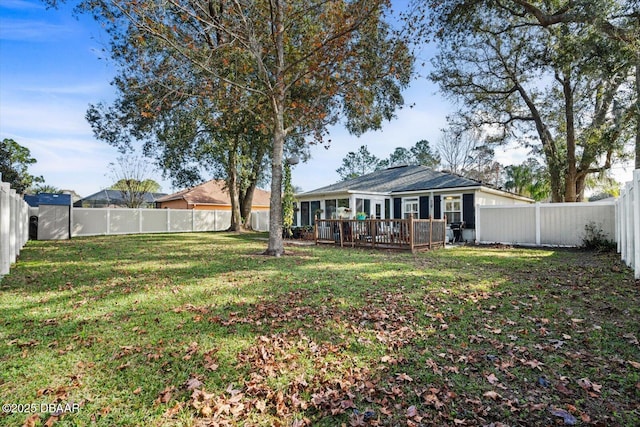 back of house featuring a wooden deck and a yard