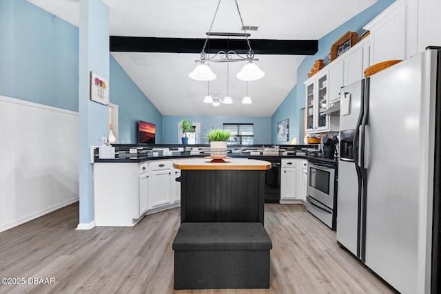 kitchen featuring white cabinets, vaulted ceiling with beams, appliances with stainless steel finishes, a kitchen island, and kitchen peninsula