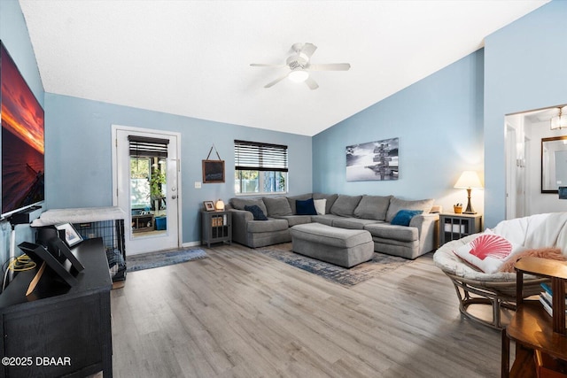 living room featuring wood-type flooring, ceiling fan, and lofted ceiling