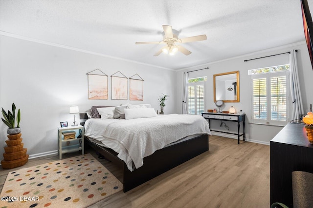 bedroom with a textured ceiling, light hardwood / wood-style floors, ceiling fan, and crown molding