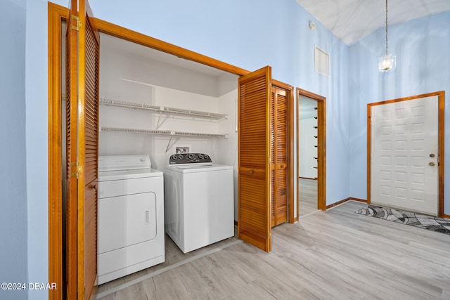 clothes washing area featuring light hardwood / wood-style flooring and washing machine and dryer