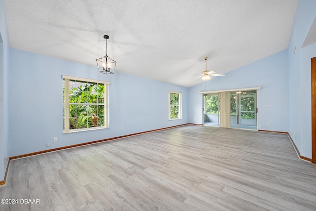 unfurnished room featuring a textured ceiling, lofted ceiling, ceiling fan with notable chandelier, and light hardwood / wood-style flooring