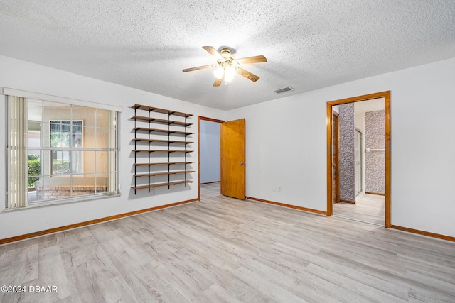 unfurnished room with ceiling fan, a textured ceiling, and light hardwood / wood-style floors