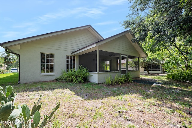 rear view of property with a sunroom and a yard