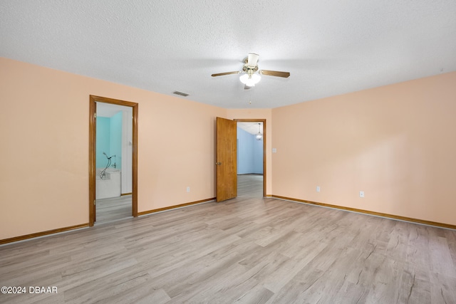 empty room featuring a textured ceiling, light hardwood / wood-style floors, and ceiling fan