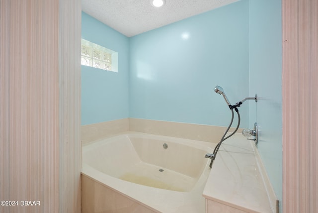 bathroom with a textured ceiling and a washtub