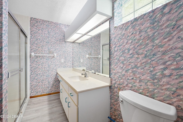 bathroom with toilet, vanity, wood-type flooring, and walk in shower