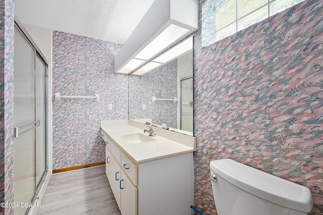 212 Glenbriar Cir, Daytona Beach, FL 32114 - bathroom with wood finished floors, wallpapered walls, toilet, a stall shower, and vanity