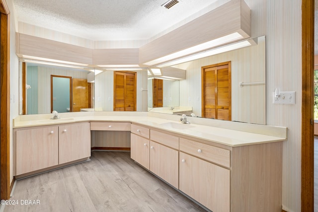 bathroom featuring vanity, hardwood / wood-style floors, and a textured ceiling