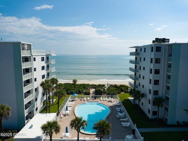 view of pool with a view of the beach, a patio area, and a water view