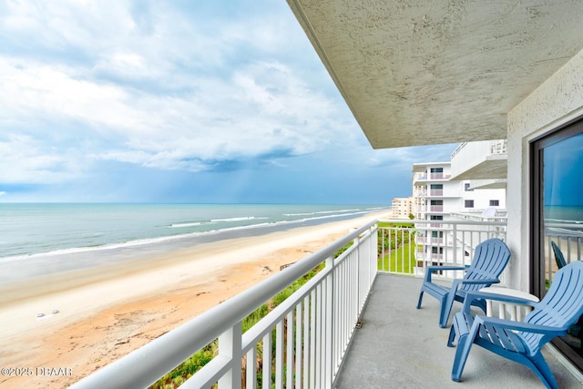 balcony featuring a water view and a view of the beach