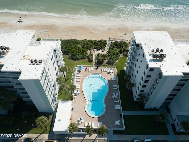 birds eye view of property with a water view and a beach view