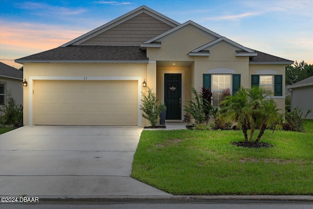 view of front of house featuring a garage and a yard