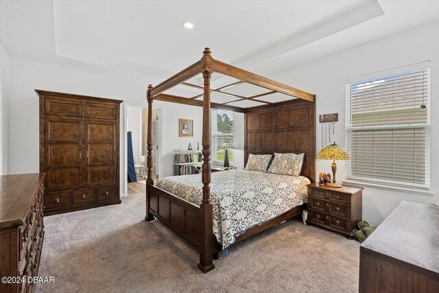 bedroom with ensuite bathroom and carpet flooring