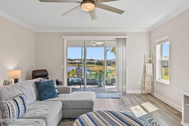 living room featuring crown molding, light wood-style floors, baseboards, and ceiling fan