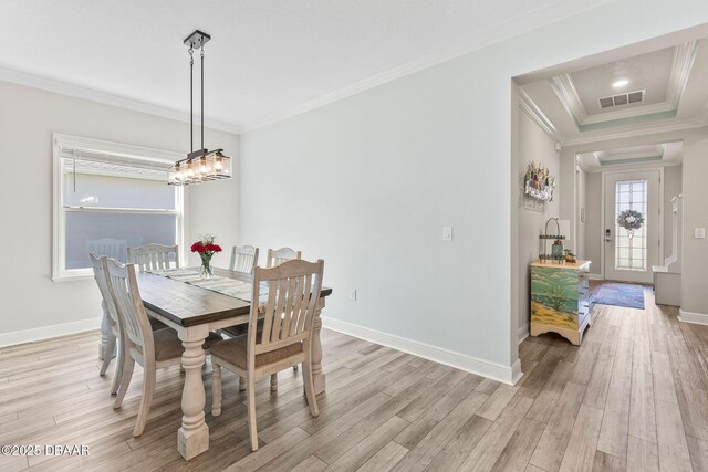 dining area with crown molding, light wood finished floors, baseboards, and visible vents