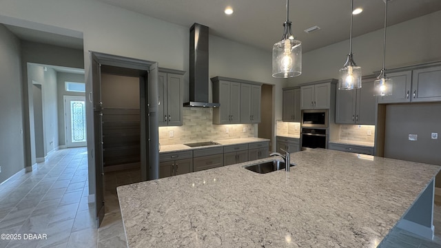 kitchen featuring a large island, wall chimney exhaust hood, sink, and stainless steel appliances